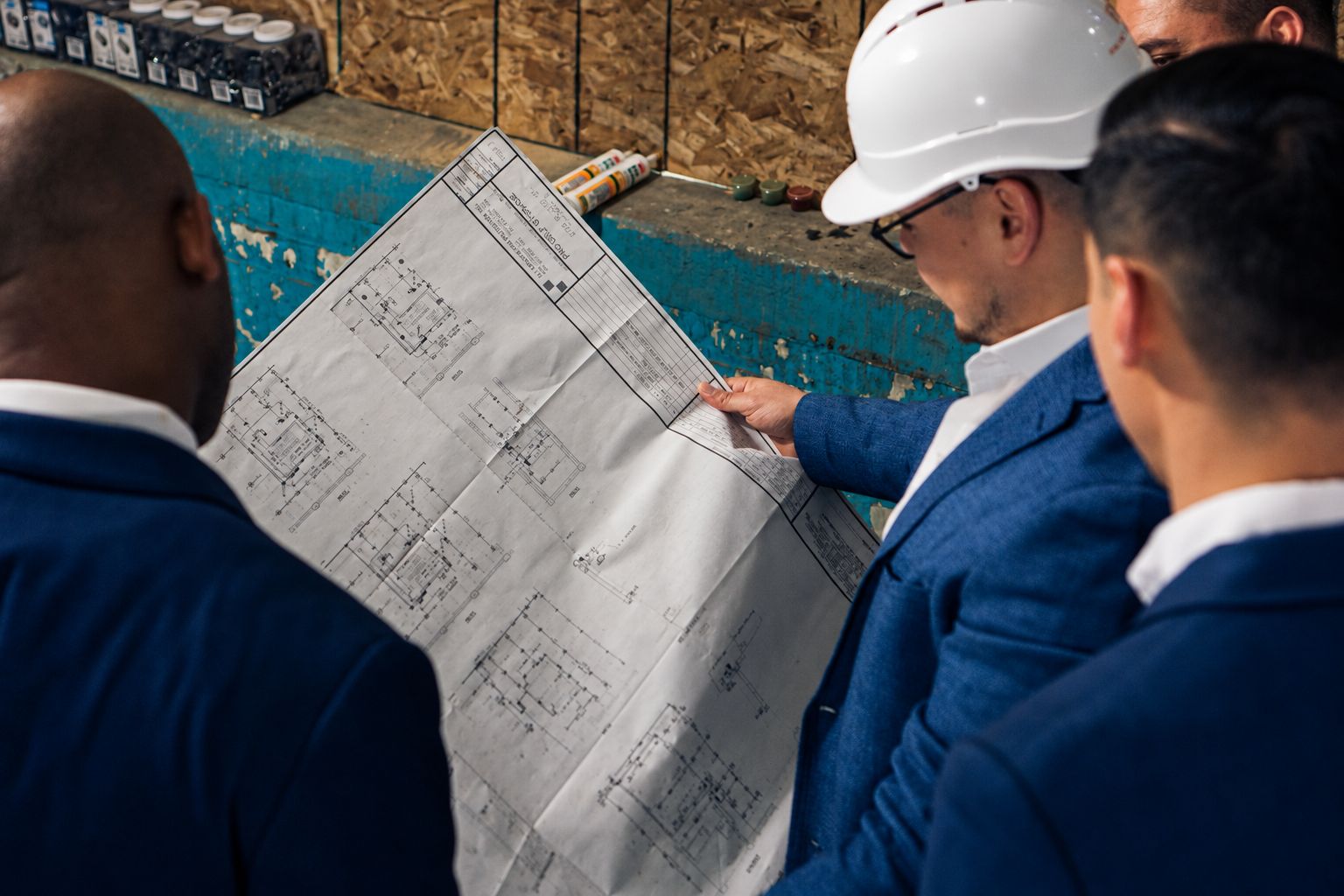 Jose Eduardo Hernandez reviewing building plans with a team on a job site