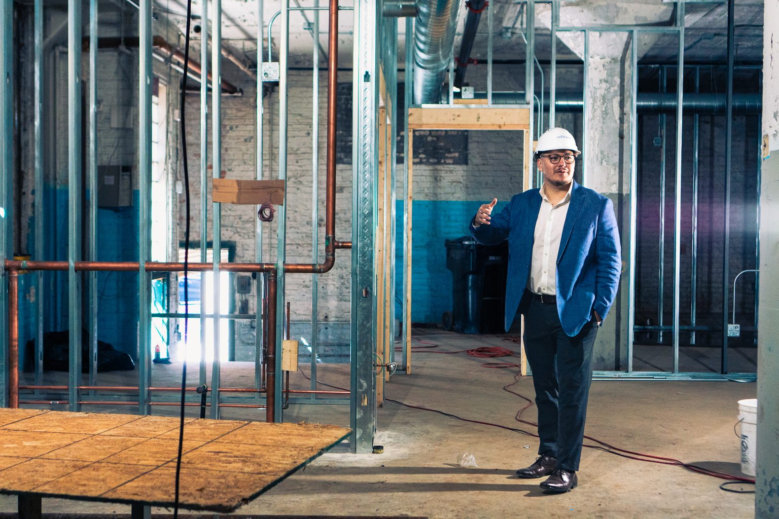 Jose Eduardo Hernandez in a hard hat inside a building under renovation